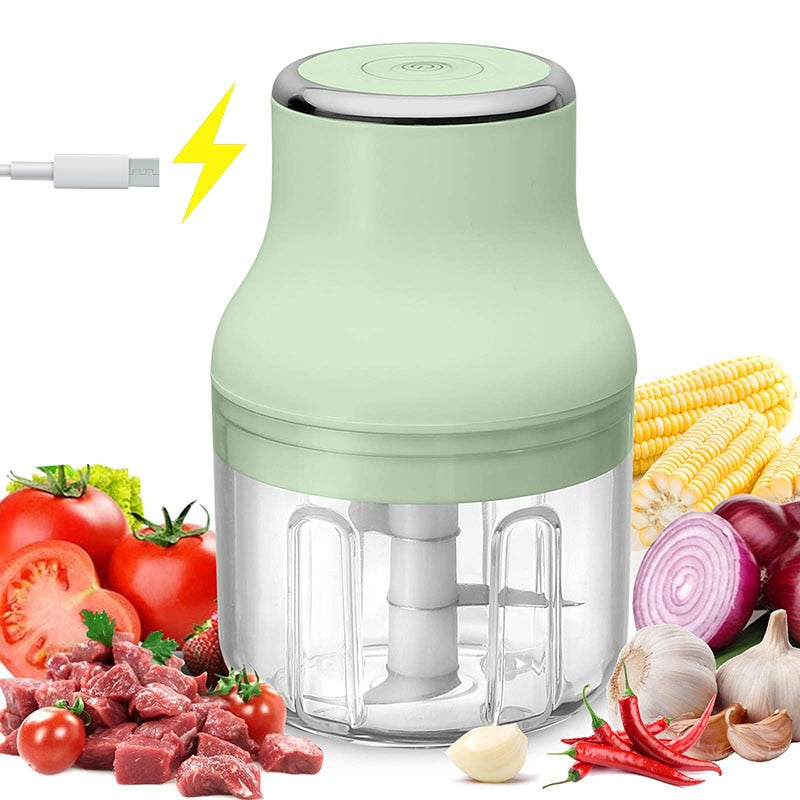 Green Mini Electric Food Chopper surrounded by ingredients that can be chopped and also a cord showing that it is a chargeable device