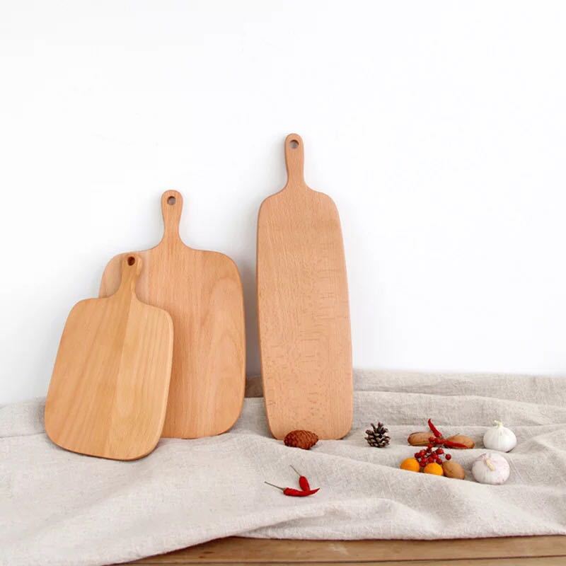 3 of the Wooden Chopping Board Set against a wall resting on a rug accompanied by various ingredients
