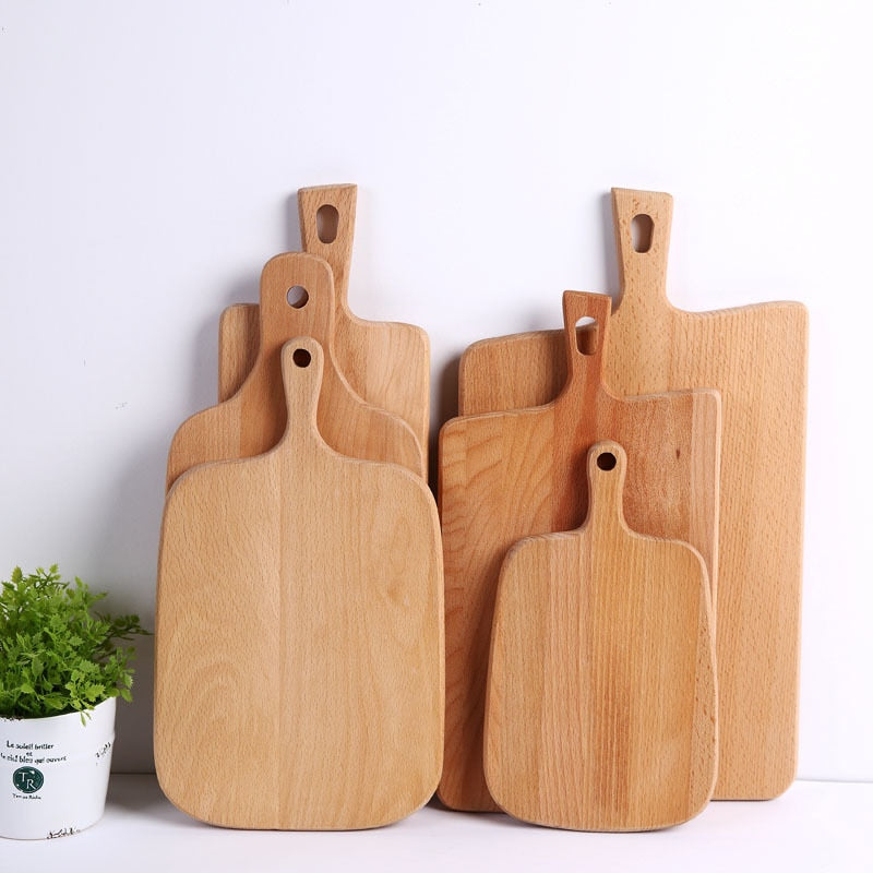Wooden Chopping Board Set against a wall next to a plant